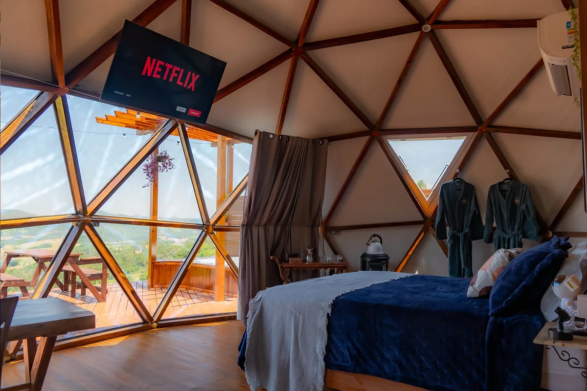 Interior do Chalé Lua, domo geodésico com cama e deck ao fundo
